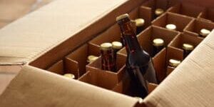 Unpacking a package of beer bottles from different breweries. Craft Beer from foreign countries or national micro breweries are hardly available in most regular stores. Online shops offer Craft beer or a selection of special beer and deliver it.
