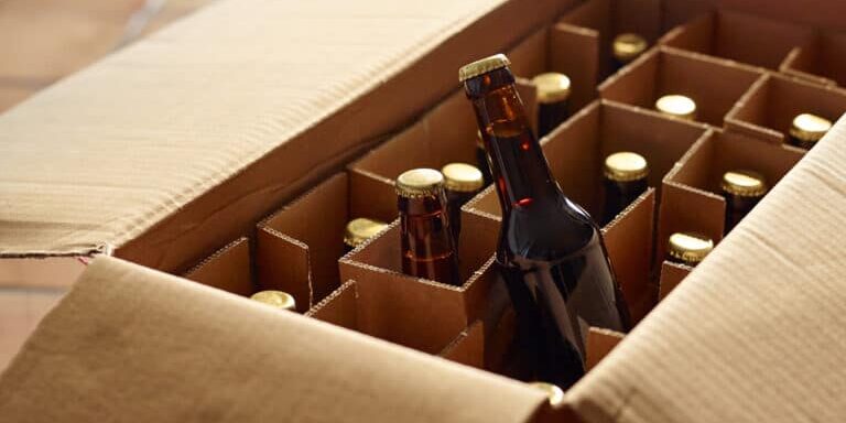 Unpacking a package of beer bottles from different breweries. Craft Beer from foreign countries or national micro breweries are hardly available in most regular stores. Online shops offer Craft beer or a selection of special beer and deliver it.